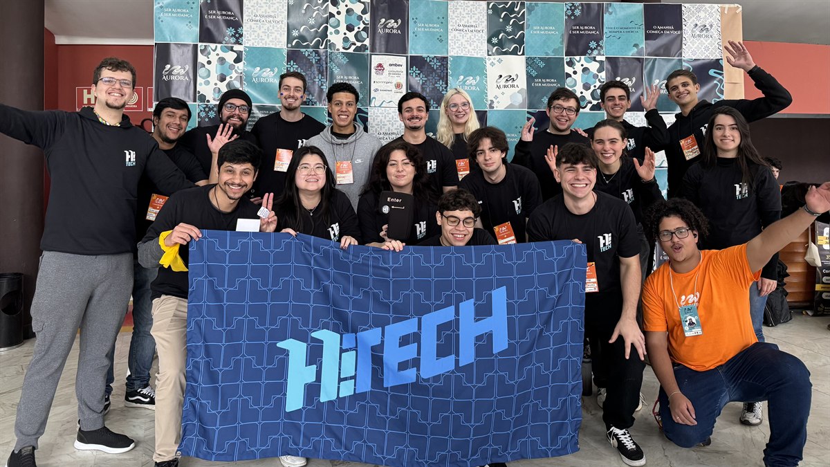 Equipe Hï Tech reunida segurando a bandeira da empresa